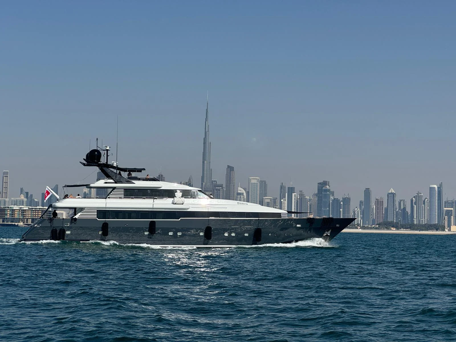 Die INDIGO STAR I mit dunklem Rumpf vor der Skyline von Dubai
